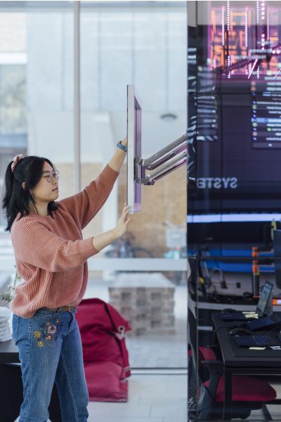 A student adjusting a screen in The University of Melbourne's NExT Lab