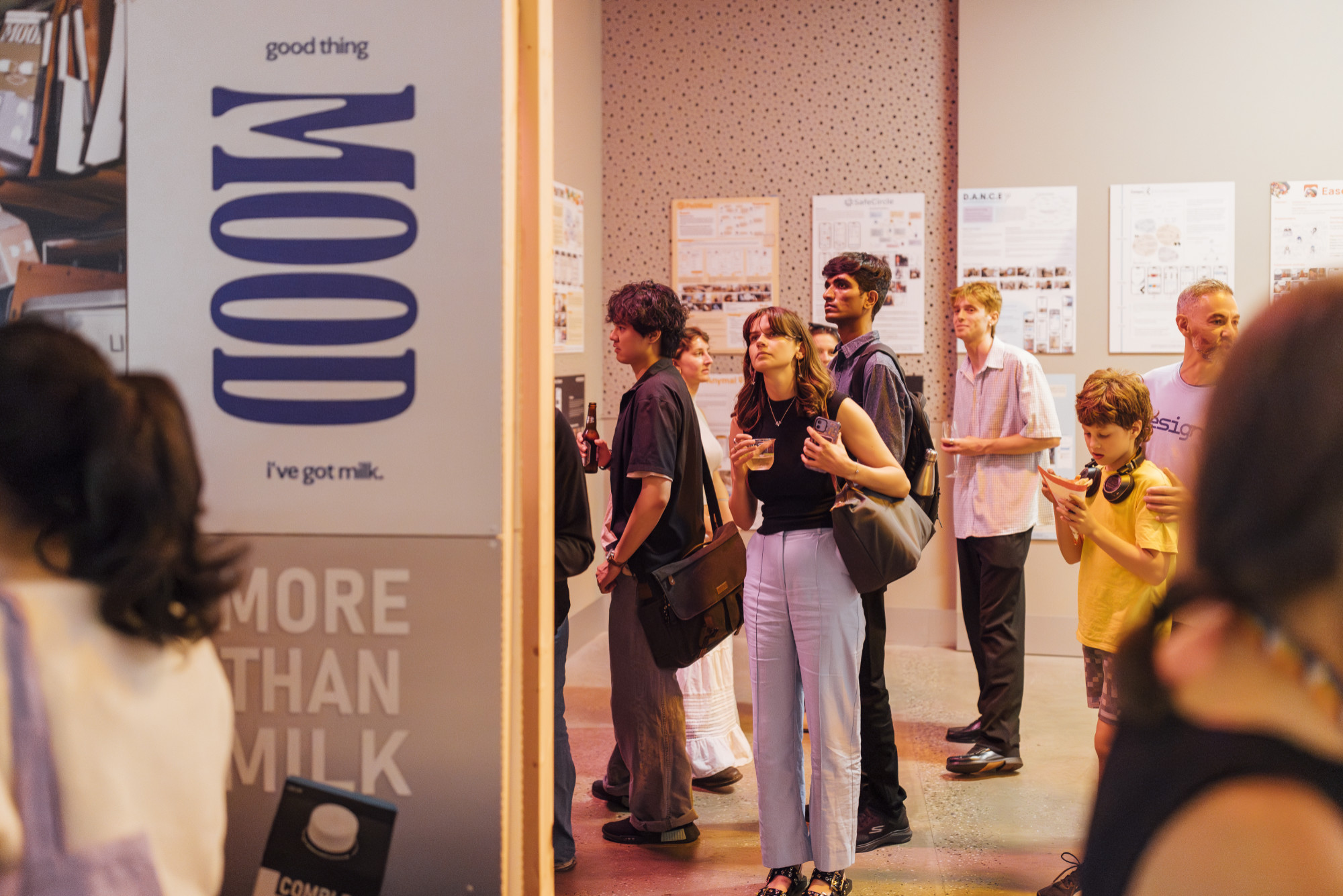 A person holding a drink looks up at an exhibition display at MSDx