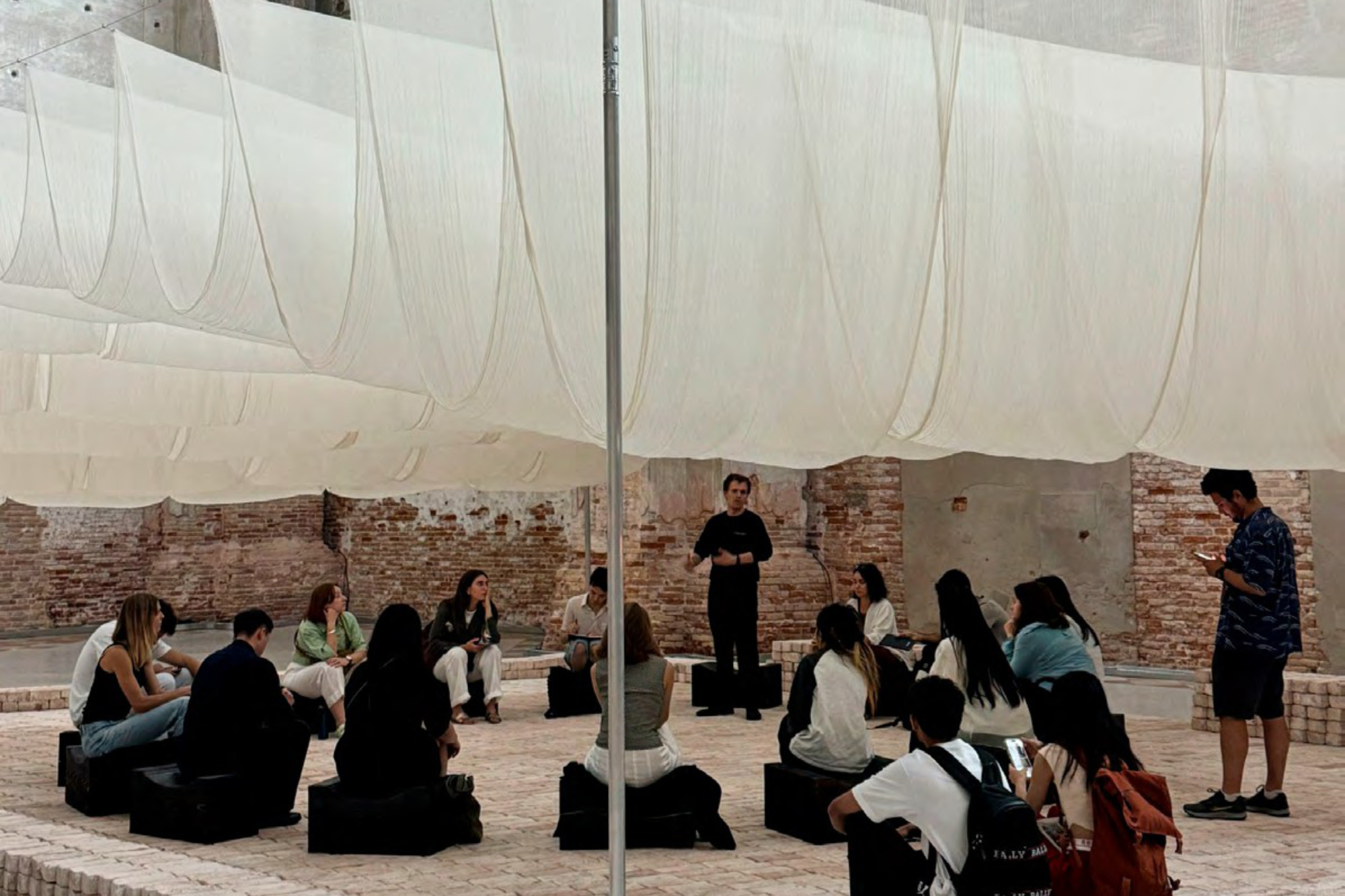 Students listen to a presented at a studio in Venice