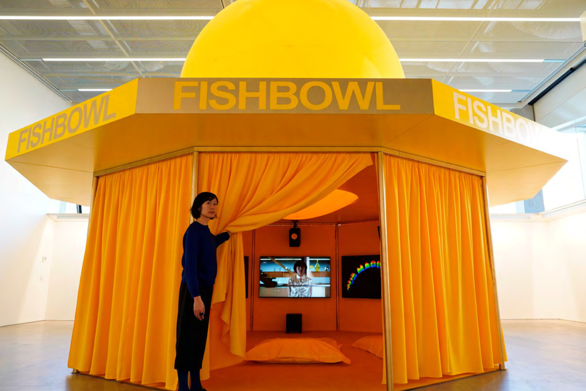  person draws the curtain of a bright orange exhibit
