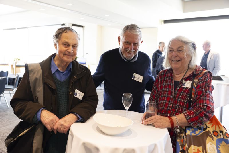 Three university alumni smiling at an event