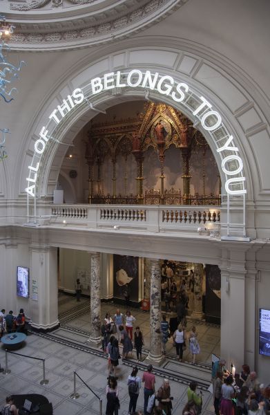 Installation of the words 'All of this belongs to you' in lights above an arch