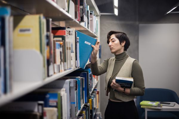 A student take a book off a shelf in the library