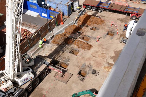 The square holes in the ground are temporary padfootings which support the temporary columns whilst the cantilever was being constructed. The load on each diagonal steel member is 150 tonnes. 