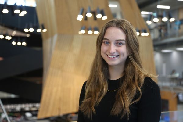 Victoria McKenzie stands in the Glyn Davis Melbourne School of Design building and smiles at the camera