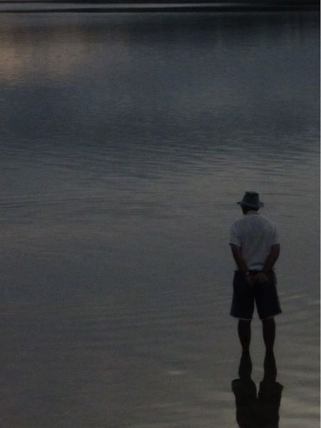 A person looks over the water at the horizon