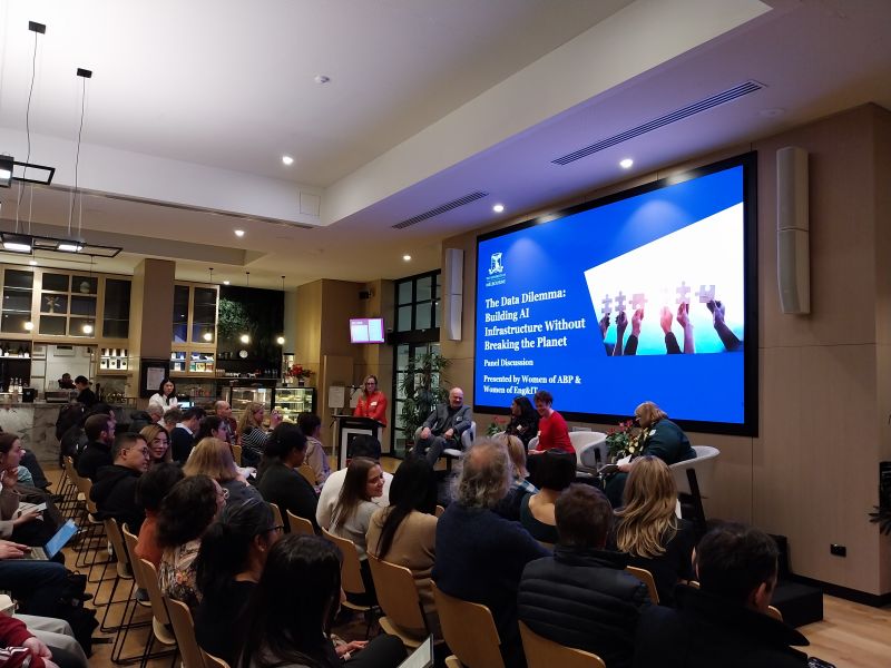A panel of people  with a screen behind them