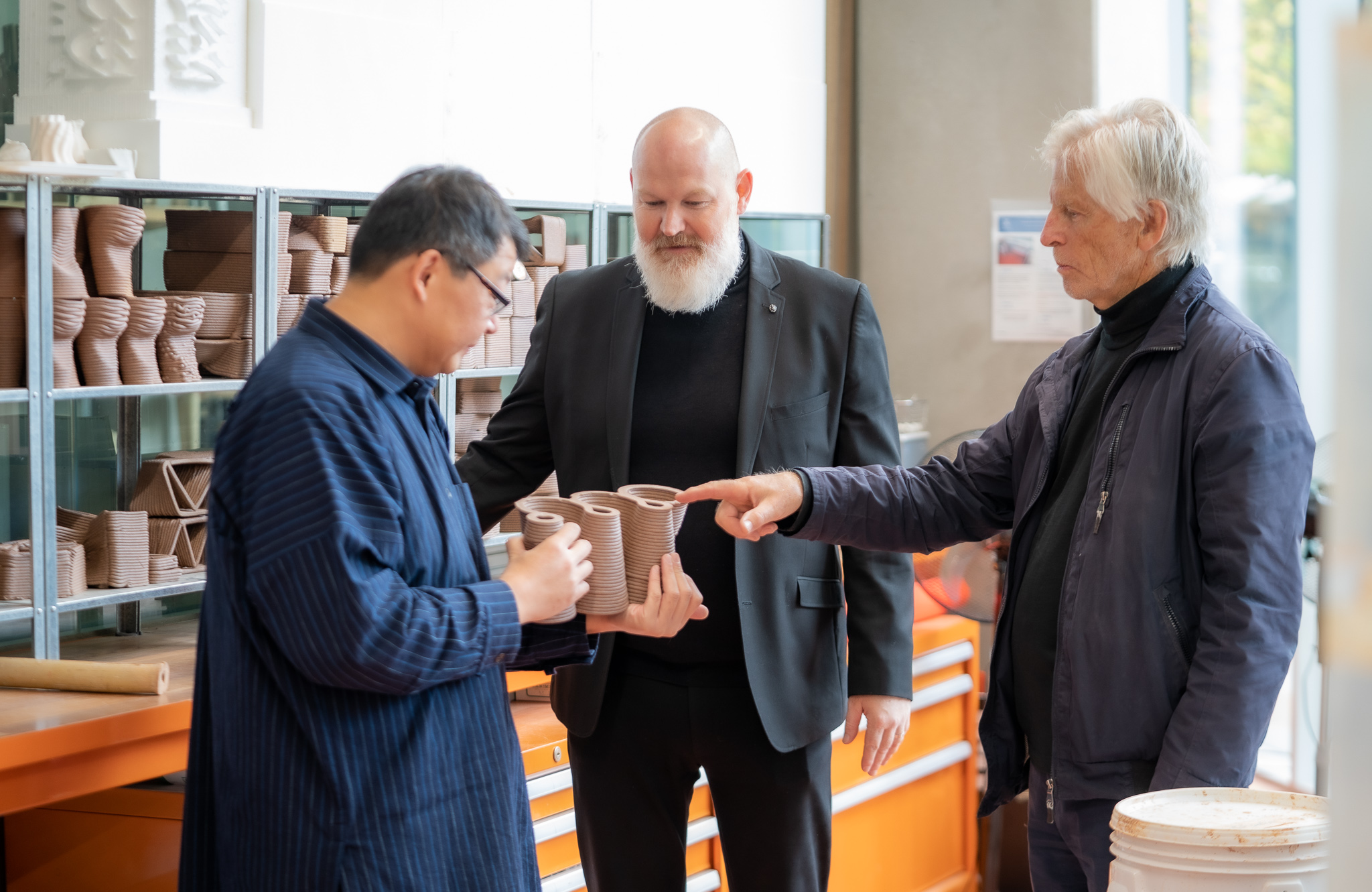 Dr Paul Loh, Professor Alan Pert and Robert Treseder in the Fabrication Workshop examining ceramics