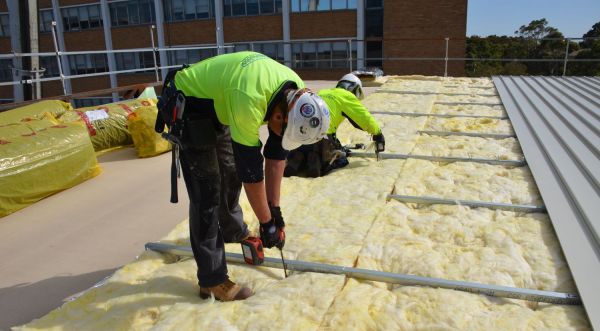 Laying down the insulation and Colorbond roofing.