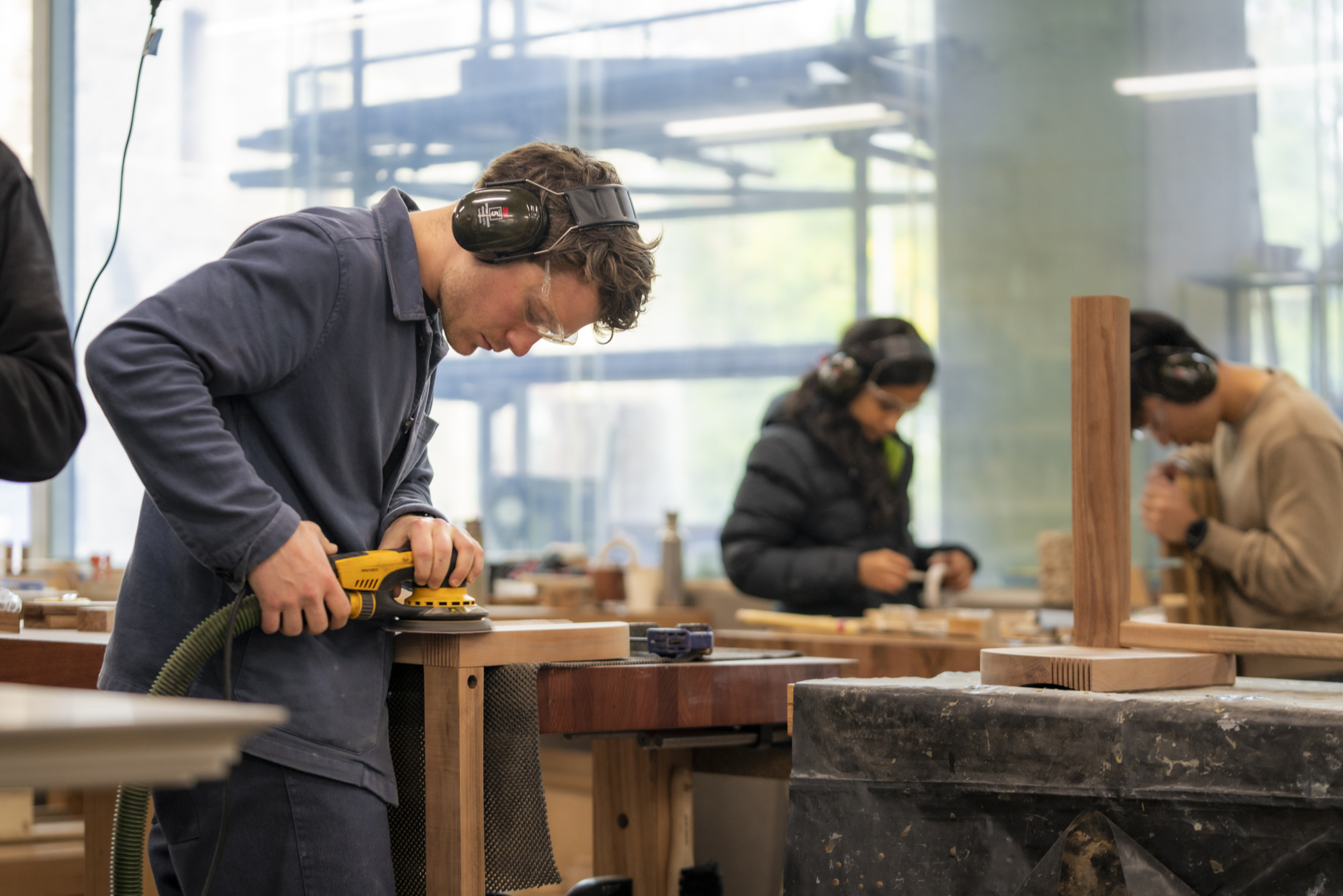 A person in PPE working with woodwork tools