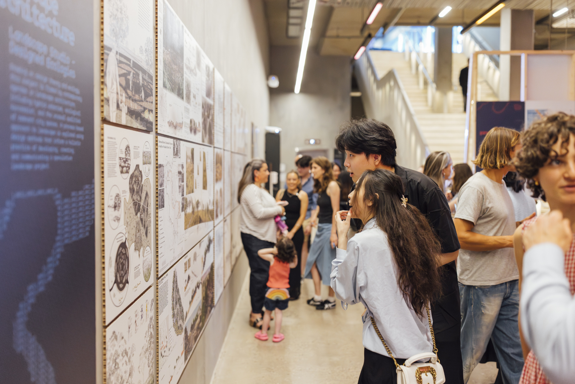 Side profile of two people looking at architectural drawings on a wall