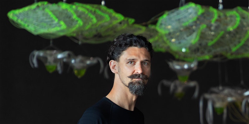 Marco Poletto stands in front of a neon green sculpture