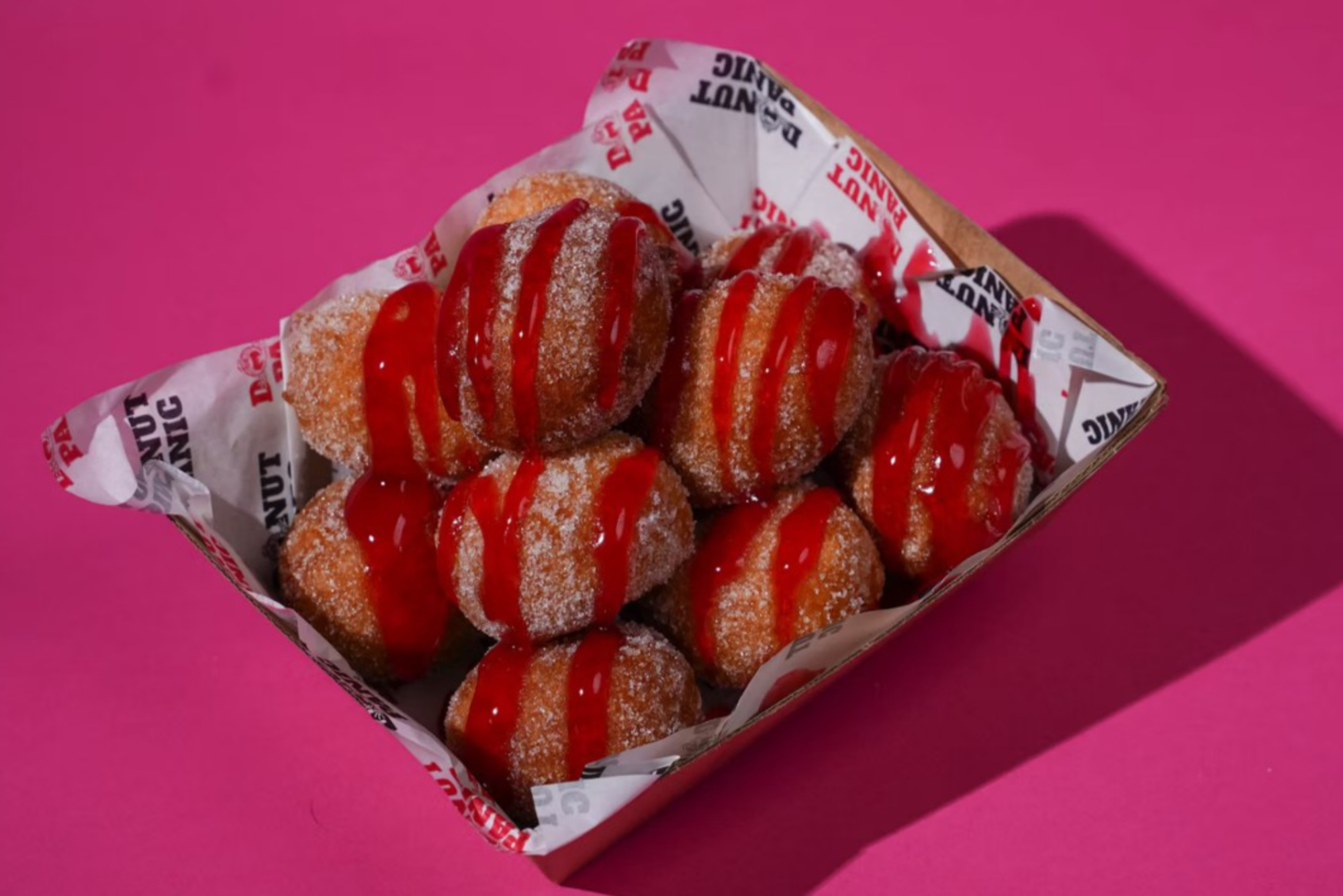 sugared donuts against a pink background