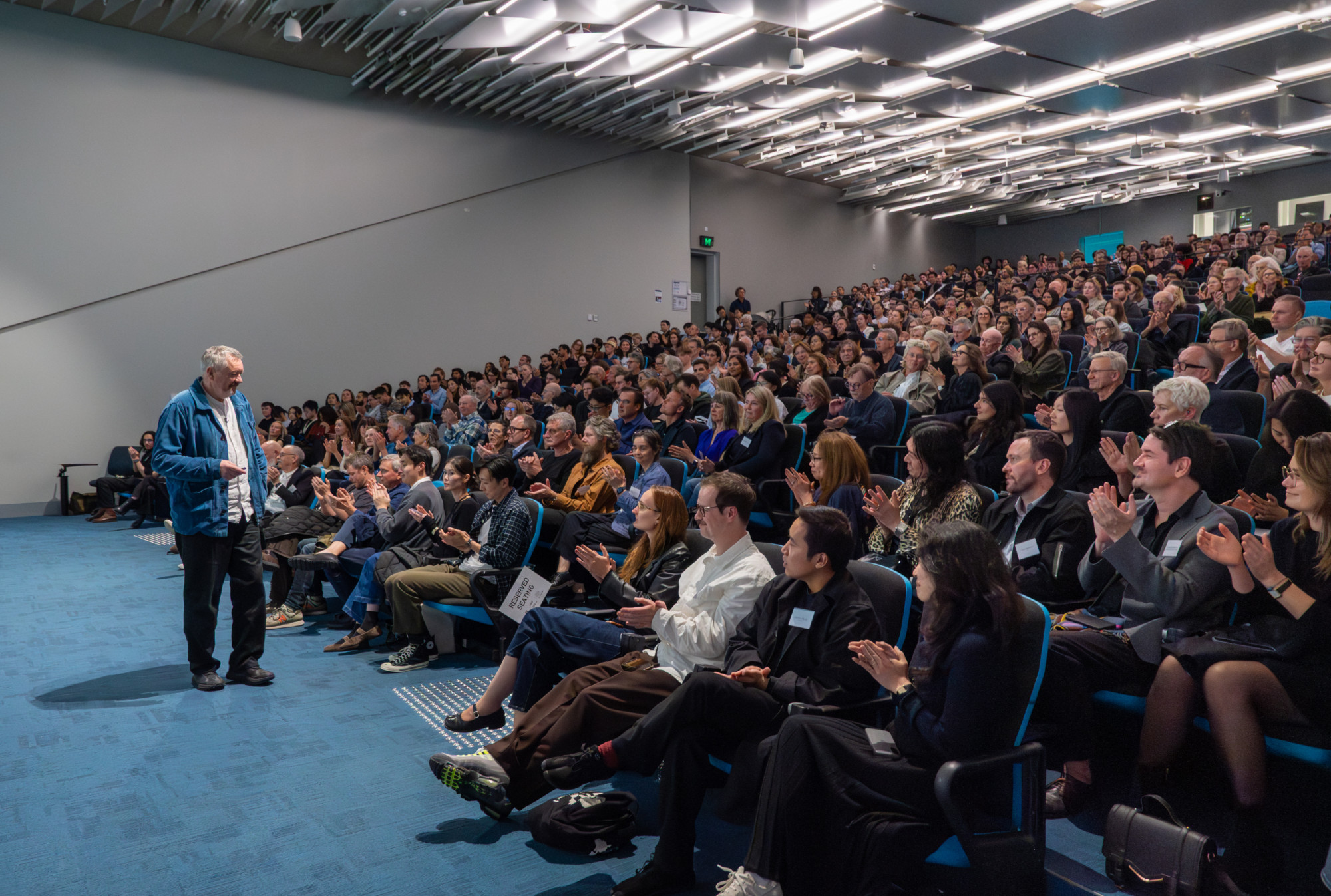 A full audience at a lecture in B117 theatre