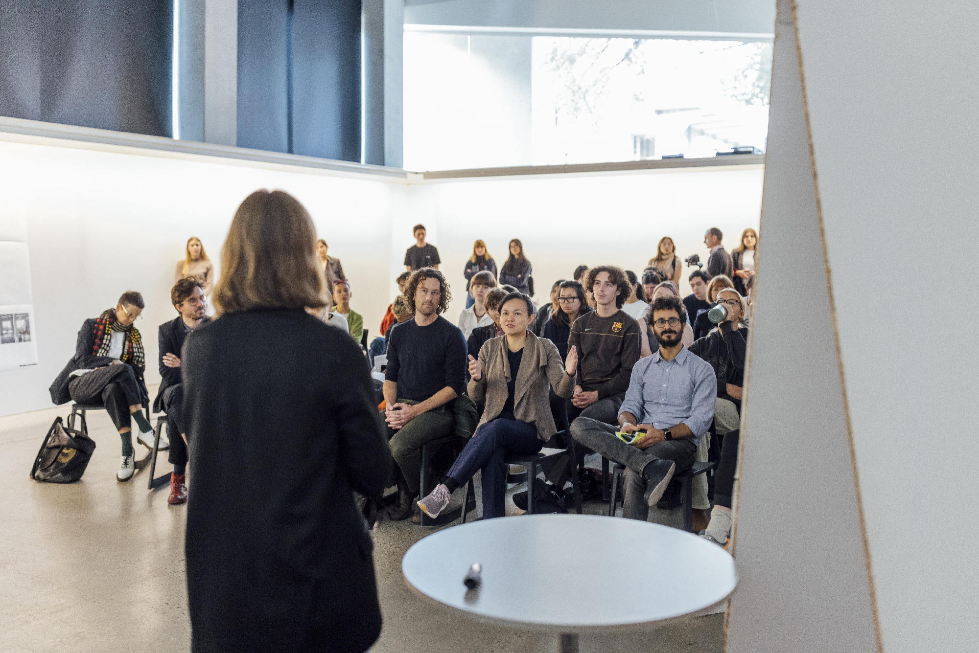 A person with their back to camera speaking to an audience